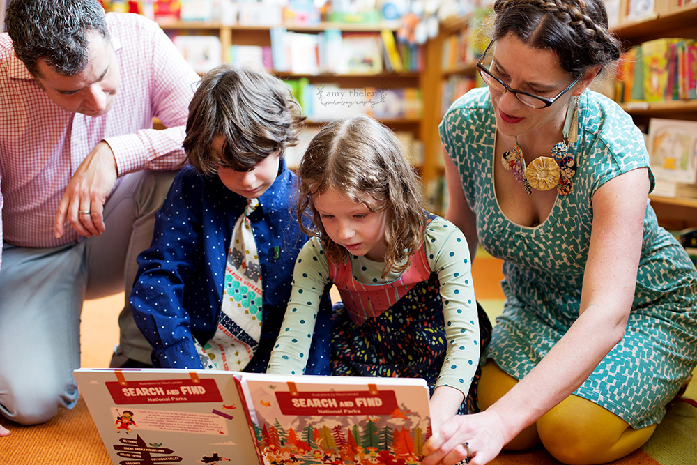 family of four sharing a book