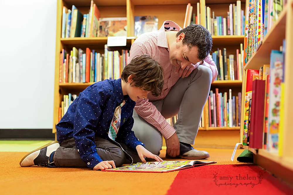 father and son looking at book