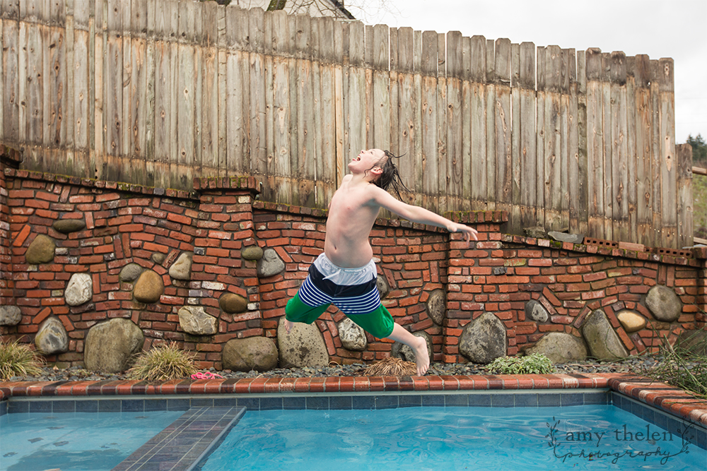 boy wildly jumping in pool