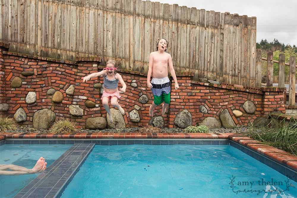 boy and girl jumping in pool