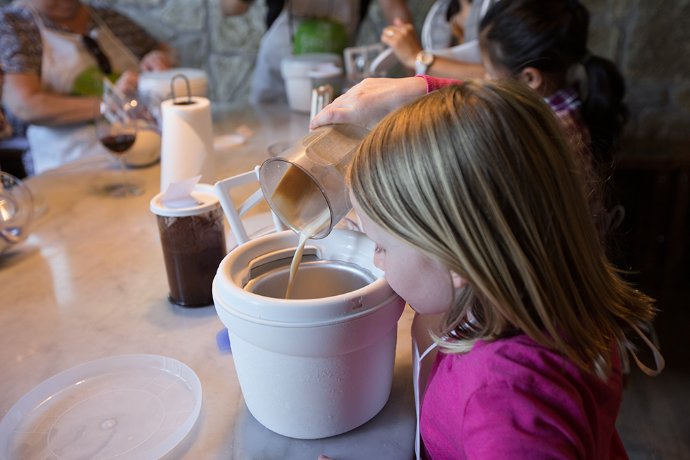 girl pouring cream mixture into ice cream maker