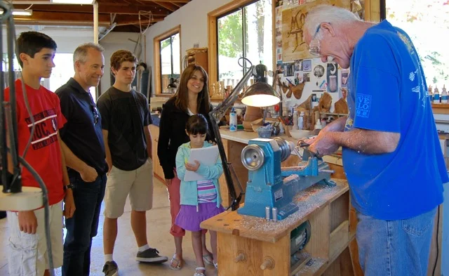 Visitors to Open Studios enjoy watching jerry turn colorful tops for the kids.