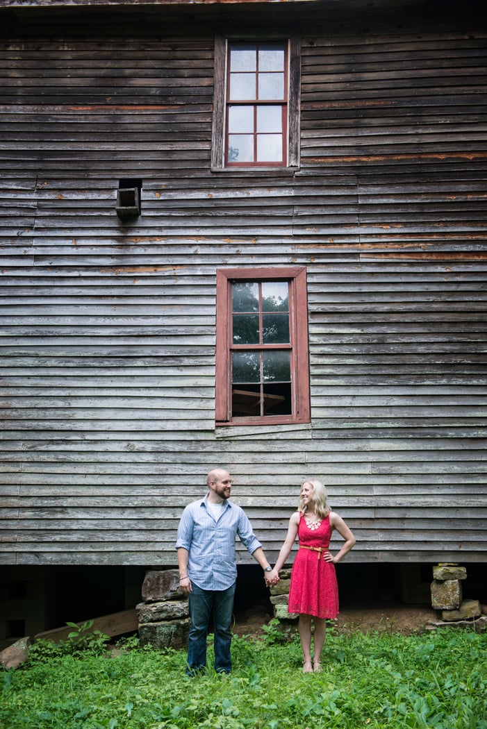 Couple holds hands near an old building