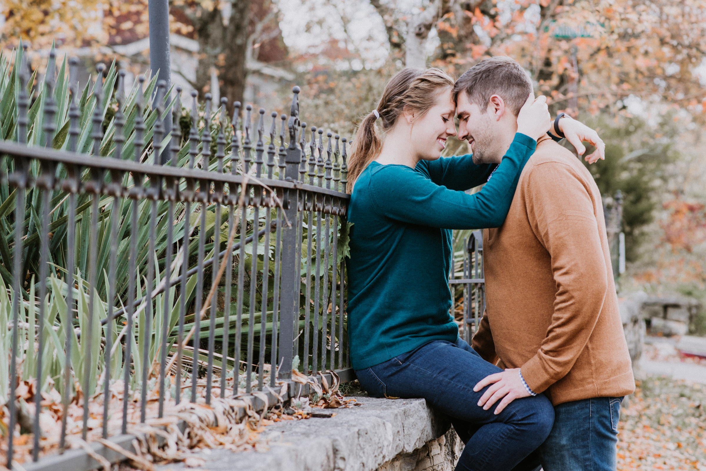 Engaged couple by wrought iron fence