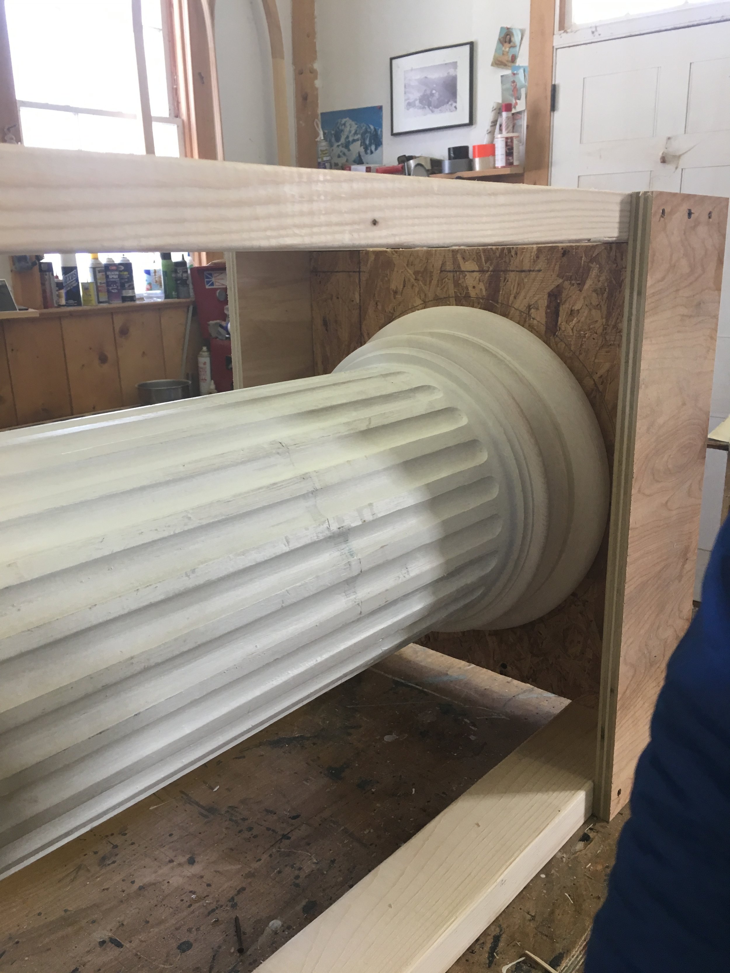 The bottom of the column after restoration, prior to being shipped back. The damaged staves were carefully cut away to minimize losses of original material, replaced with new wood of the correct species, and fluted by hand. The replacement base was also recreated out of the correct wood, using the remnants of the original base as a template.
