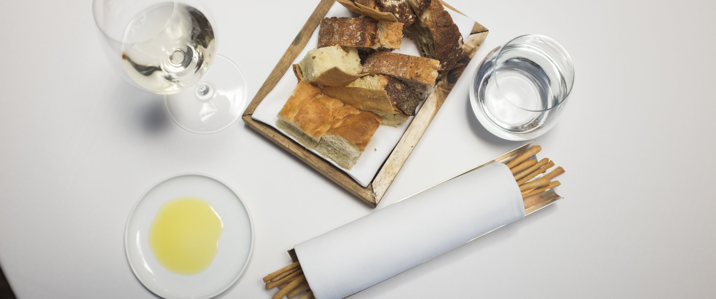 Casual. Šviežia itališka duona su traškia plutele, focaccia, duonos traškučiai ir plonos grissini lazdelės. Ir alyvuogių aliejus. Casual. Fresh Italian bread with crispy skin, focaccia, bread chips and slim grissini sticks. And extra virgin olive oil.