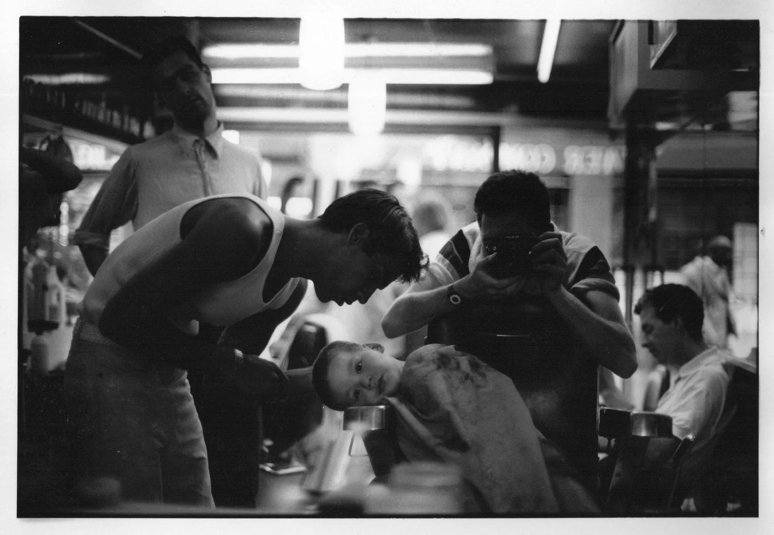 Tyrone having his hair cut in the shop as a kid, photographed by Kadir Guirey.