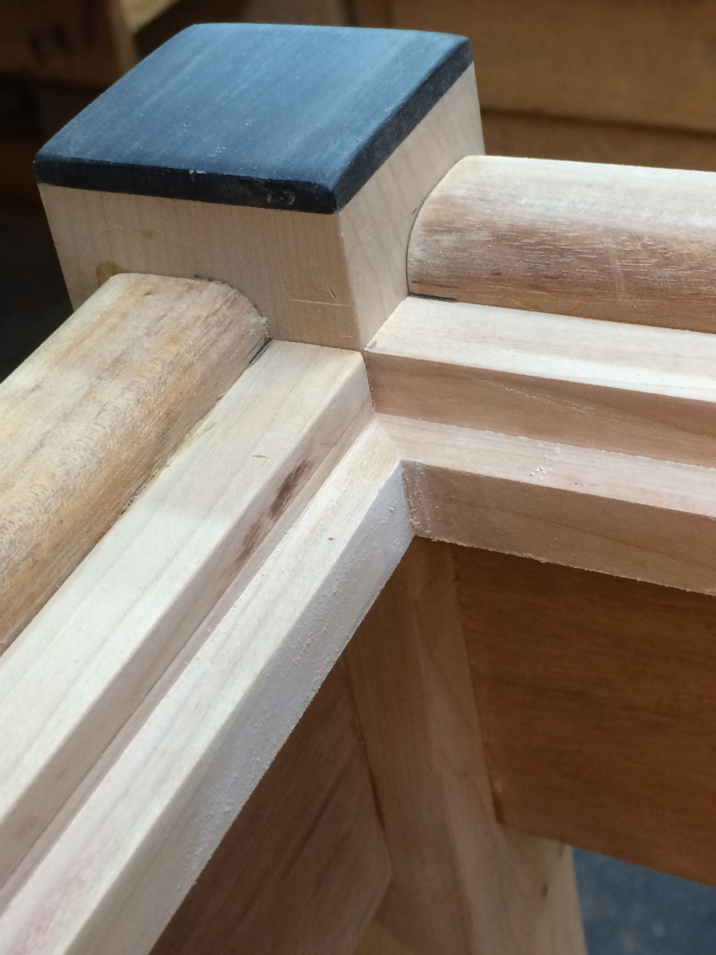A close-up, showing the roughed-in dadoed edge. The legs (ebony capo) and ledge are cherry, the aprons are goncalo alves.
