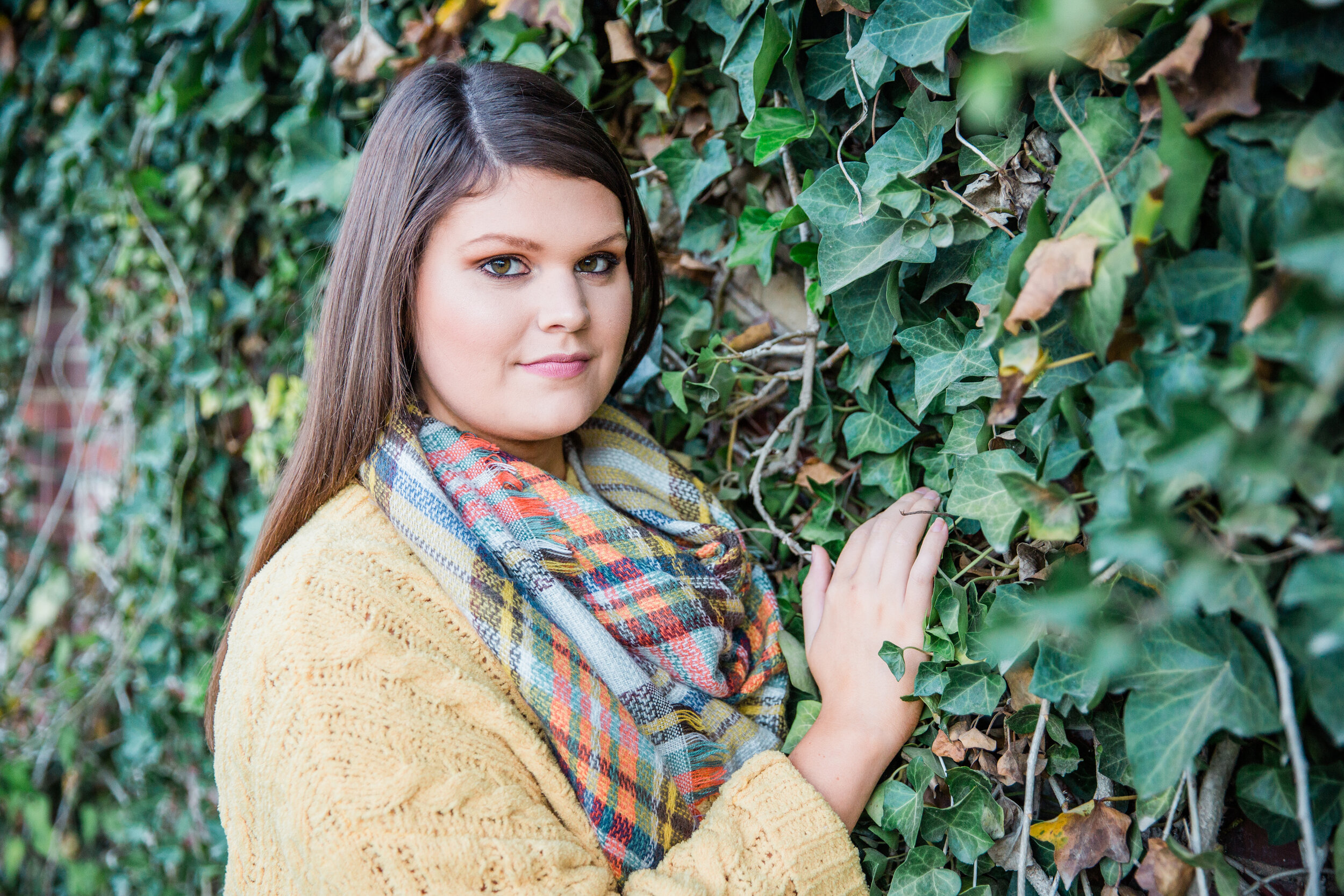 high school senior standing in front of ivy wall at old woolen mill in Cleveland Tennessee