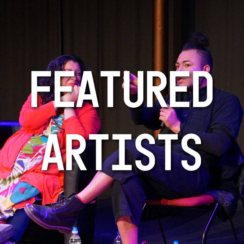 Image description: Travis Alabanza talks to one of his peers on stage. Text on the image reads: 'Featured artists'