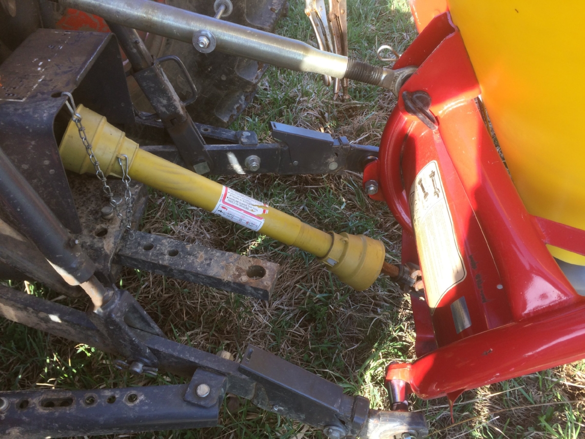 This is looking down at the back side of the tractor--the drawbar hitch is not in use (in the center), but the seeder is hooked up to the three points of the 3pt. The yellow shaft is the spinning PTO (more on that later).