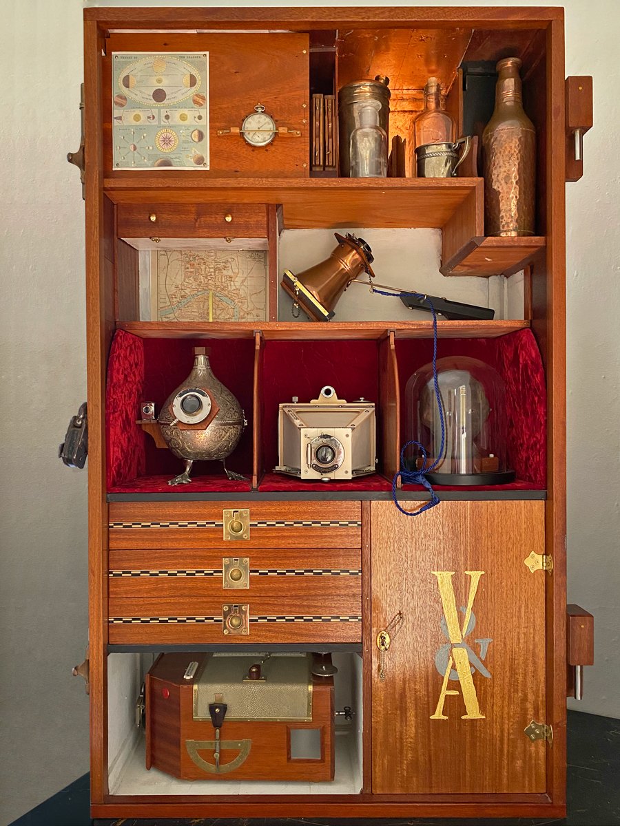 Beauchamp, an avid amateur photographer, builds himself five cameras from parts scrounged during visits to the Grand Bazaar. He has converted his travel trunk to a neatly fitted-out camera storage unit.