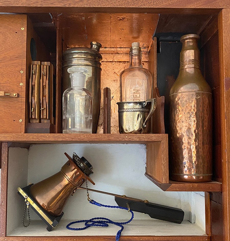 Ever resourceful, Beauchamp mixes chemicals and develops his film in a sterling silver cocktail shaker. The Gordon’s Gin bottle holds fixer.