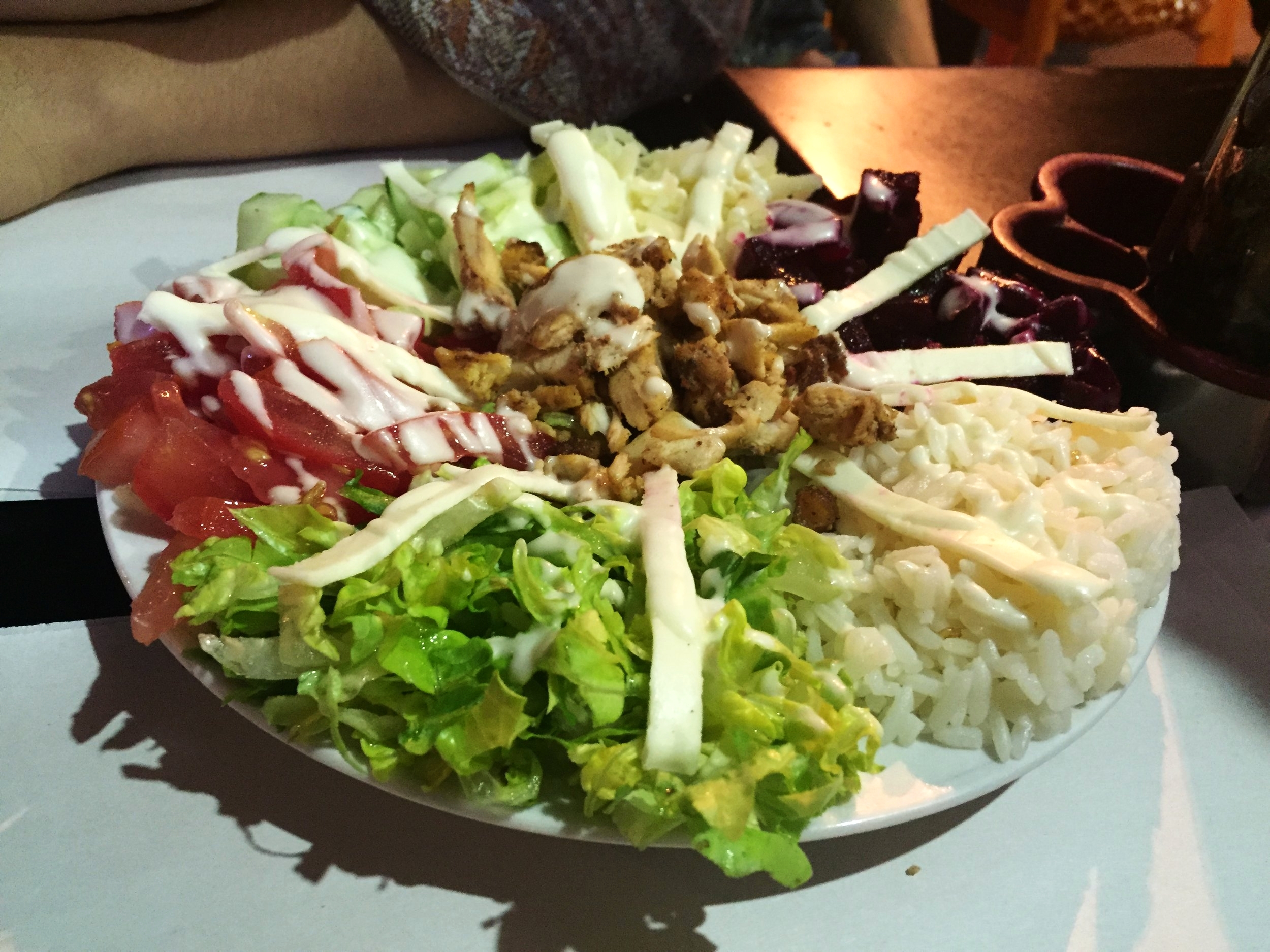 Moroccan salad with tomatoes, rice, grilled chicken, beets and greens. 