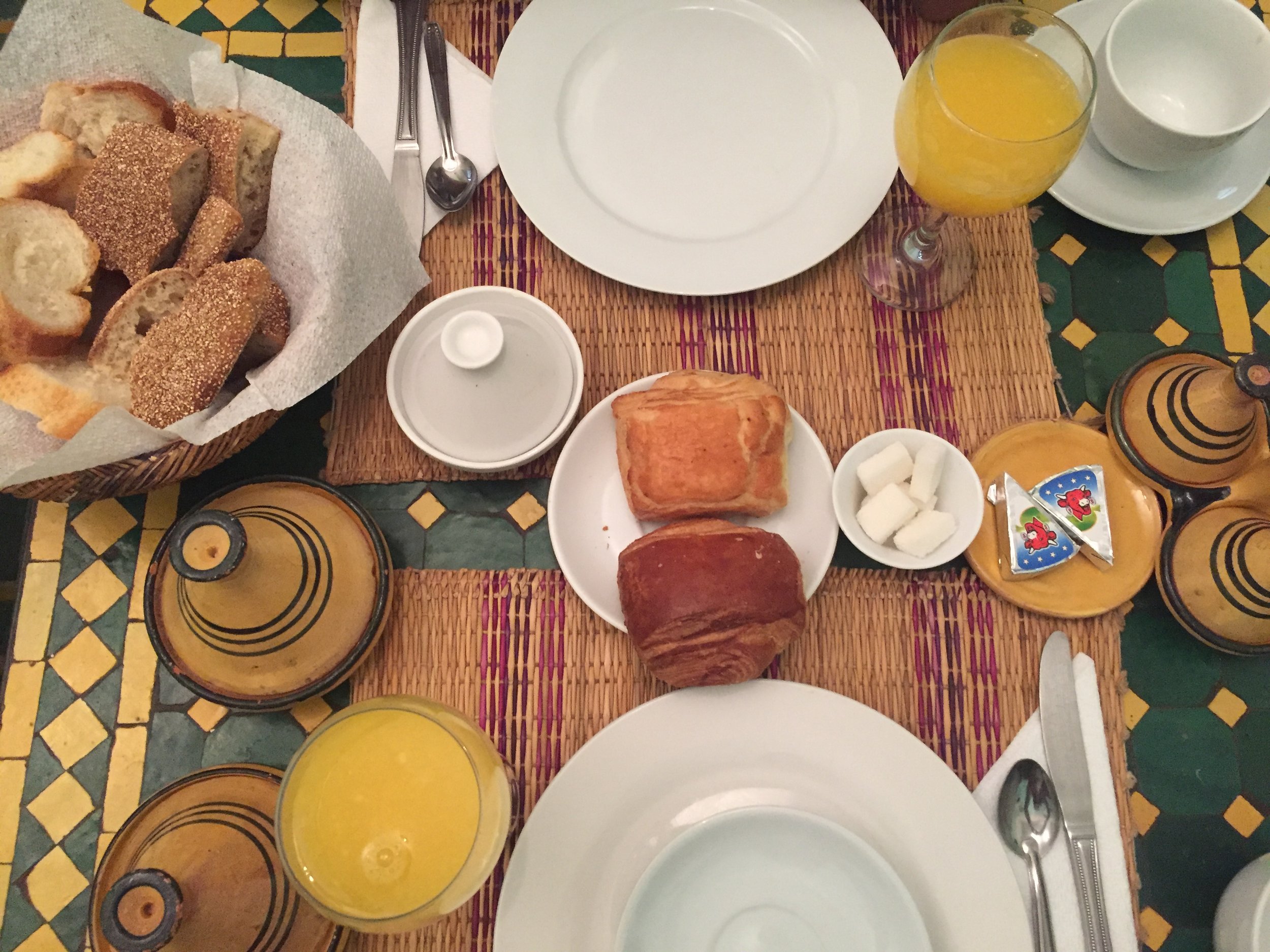 Fancy moroccan breakfast with freshly squeezed orange juice, bread, tea, crepes, jam, cheese.