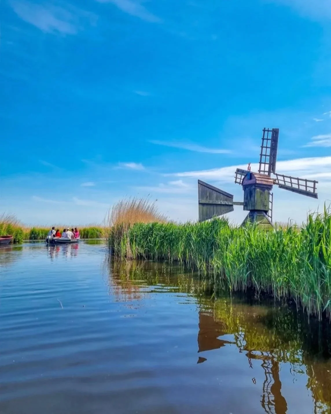 een elektrische boot die rustig door het typisch nederlandse landschap vaart
