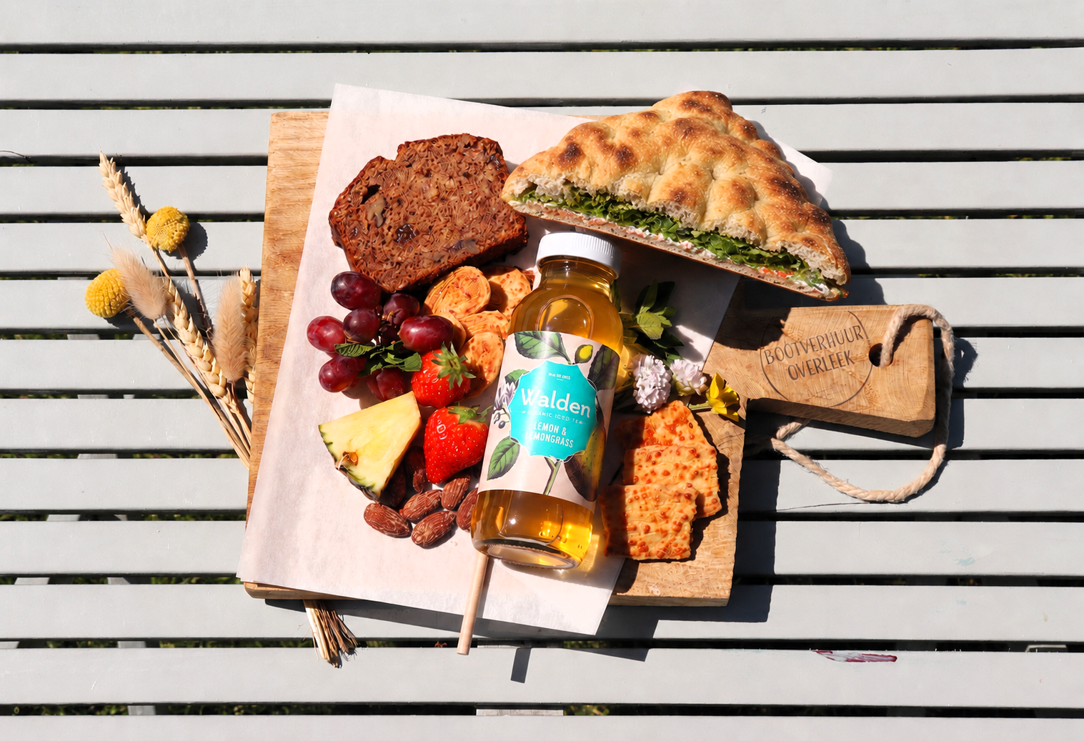 Zonnige picknick schiattiata bananenbrood vers fruit iced tea nootjes zoutjes boot varen zomer lunch