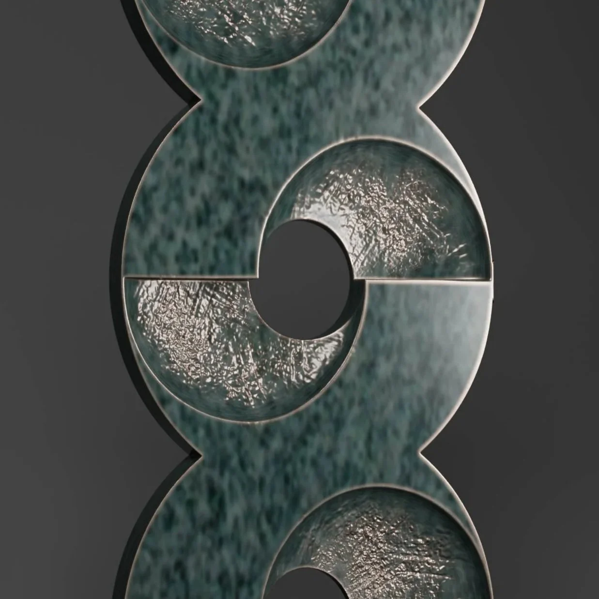 A modern abstract sculpture made of textured dark-colored material, shaped like a stylized letter 'X' with circular cutouts, mounted on a black rectangular base, against a dark background.