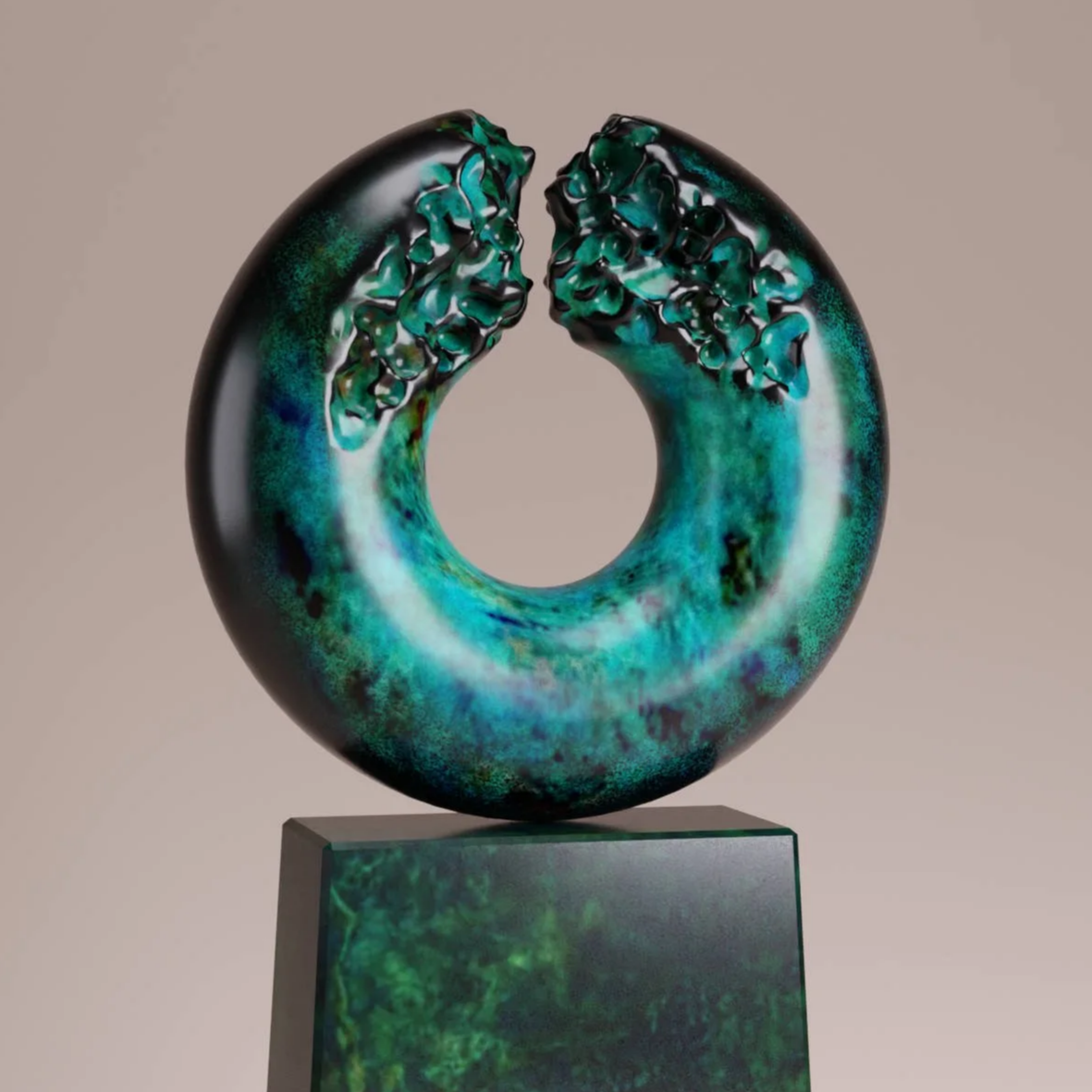 A circular sculpture with a dark outer edge and a vibrant green and blue interior, mounted on a rectangular base.