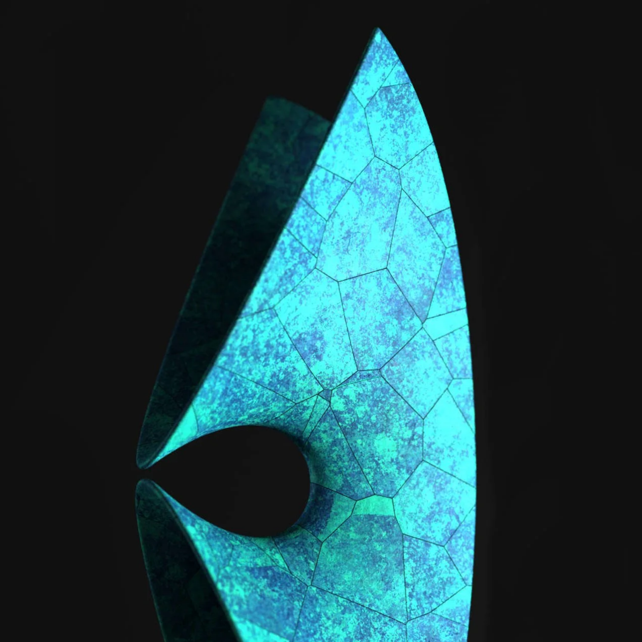 A glass sculpture resembling a stylized, elongated teardrop or flame, with a pattern of interconnected, irregular shapes in a vibrant blue color. The sculpture is illuminated against a dark background, casting a reflection on the surface below.