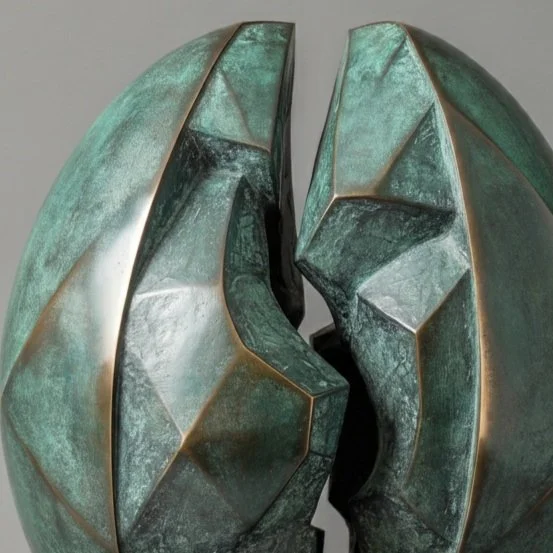 Bronze sculpture of two large eggs with a crack between them, mounted on a flat base.