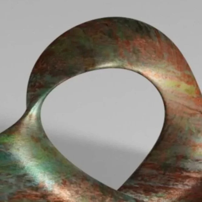 A modern abstract sculpture made of multicolored metal, shaped with a large circular hole in the middle, resting on a flat surface against a plain background.