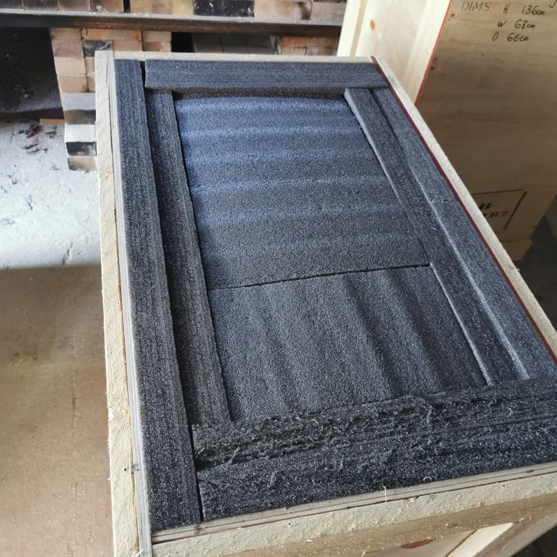 Close-up of foam insulation panels inside a wooden frame on a workbench.