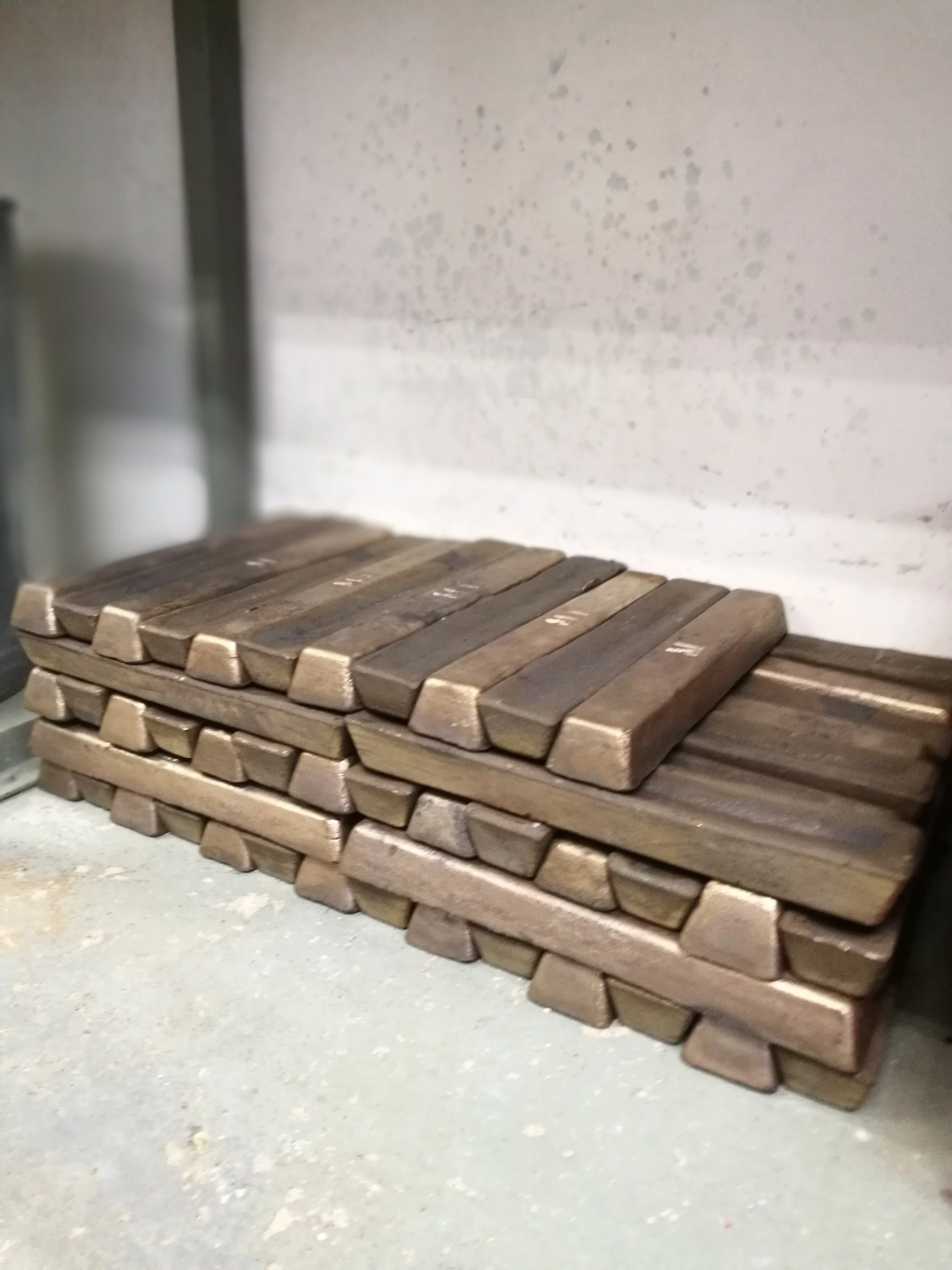 Stacked wooden pallets on a concrete floor against a wall.