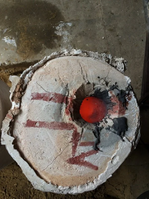 A cracked concrete surface with red lines and the word 'LOVE' painted in red, and a red ball in the center, with a black and gray fire-like substance on the right side.