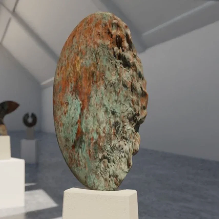 A weathered bronze sculpture of a human face in profile view on display at a museum.