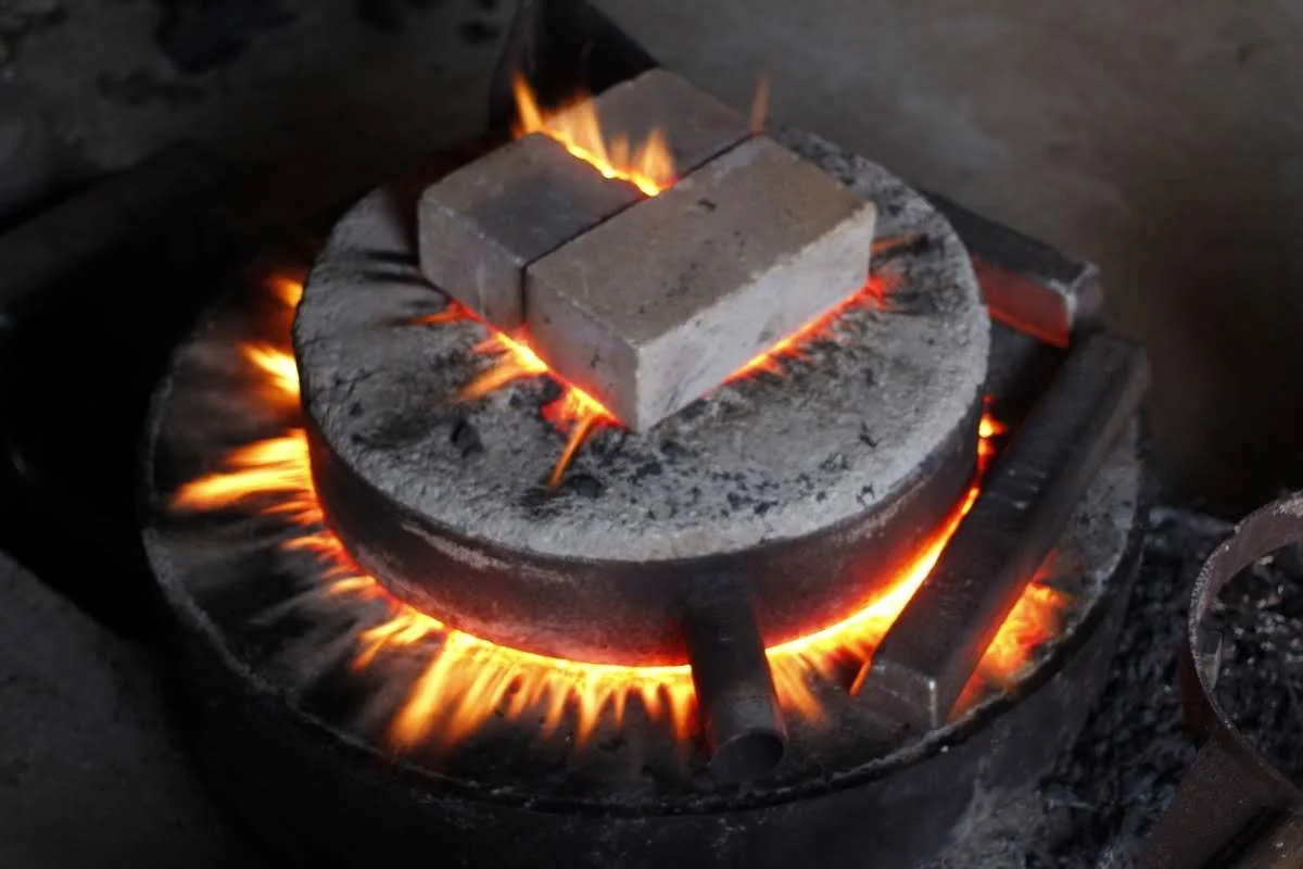 Bricks being heated on a glowing forge fire.