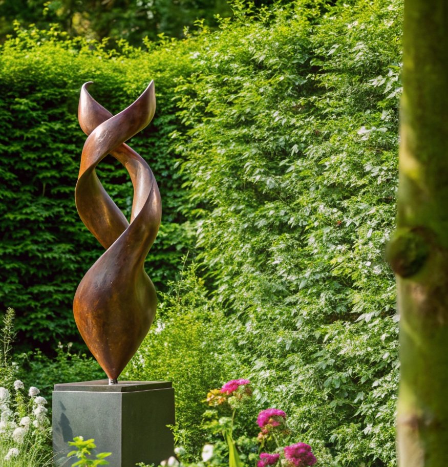 Metal abstract sculpture with twisting, elongated shapes in an outdoor garden setting.