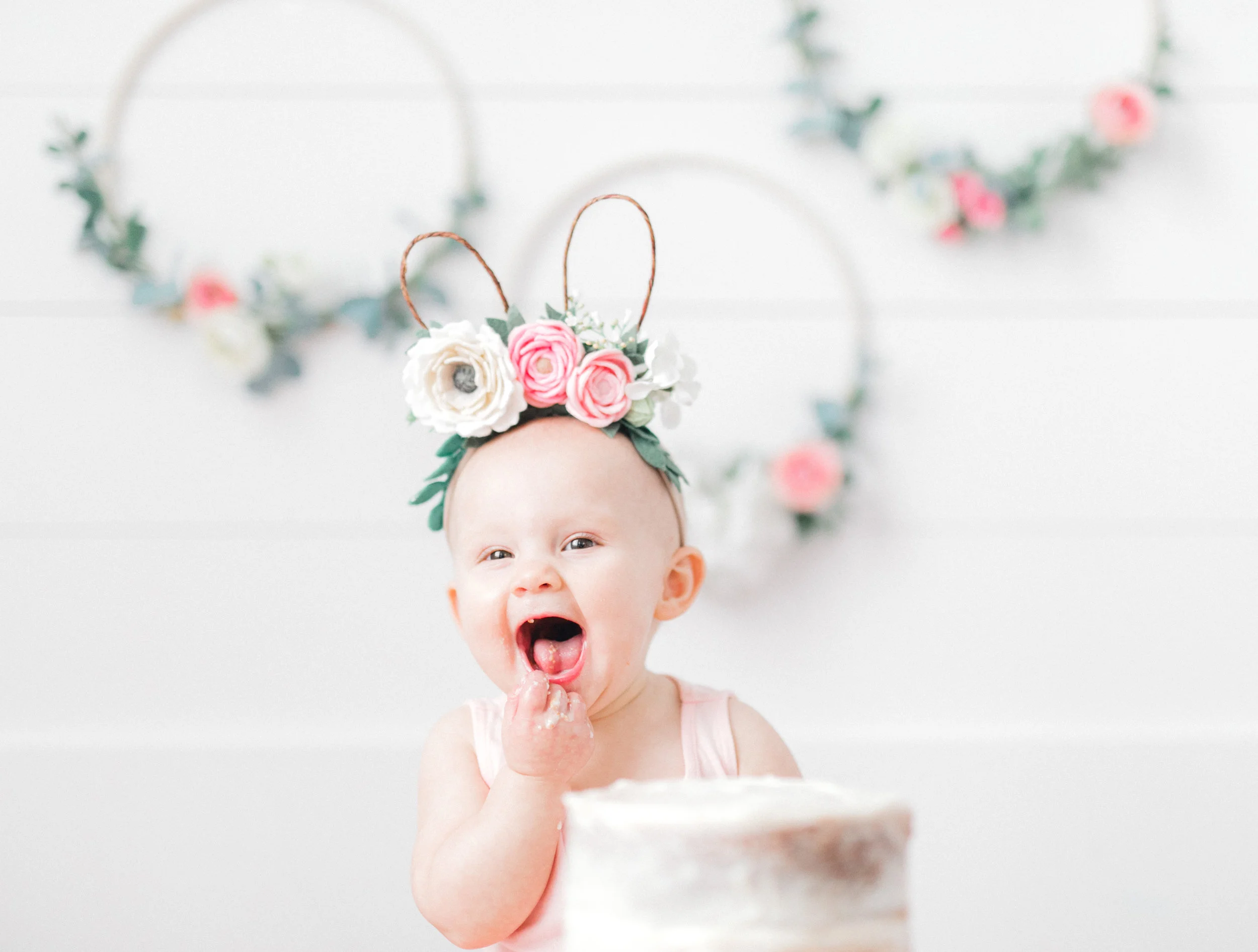 Hi friends! This is my first personal blog post, but I am so excited to share this one with you all because it is all about my sweet girl and our family these past few weeks as we celebrated her first birthday! I have always heard people say that time goes by so quickly when you have children, and y'all, they are not lying. I don't know how this past year went by so fast, but here we are and I have a one-year-old! I'm a ball of mixed emotions just thinking about it. I miss my tiny baby girl, but I love watching Anna grow into the sweet, sassy, and funny little girl that she is. I knew I wanted to do a blog post about Anna's party so that I could give credit to all the people who helped make it so special (because yes, I'm crazy, and I used a lot of my talented friends to help pull it off). The inspiration for the party came from Anna's birth date; she was born on Easter Sunday of last year, so I knew that I wanted to do something with bunnies. Bunnies have always been her theme, and we’ve called her our “Little Bunny Girl,” so that’s where I drew inspiration. Once I started looking online at bunny parties, I had a hard time figuring out which direction I wanted to go because there is A LOT of stuff out there and a lot of different decorations and bunnies! The first decorations that came together were the floral hoops (I saw them some somewhere online). I asked my friend from Covenant Threads to make them and I was blown away. Once I had the hoops, they acted as the centerpiece for everything else (the cake topper, the headbands, the flowers). I’ll give you fair warning now… if you continue to scroll through this post, there are A LOT of pictures. The weeks leading up to it and the week of Anna's birthday, I took pictures of some of the decorations for the party and we had pictures taken of the party, a cake smash session, and one-year family photos. According to my Instagram poll, you all wanted to see "ALL THE THINGS"…so that’s what I’ll show you! I’ll also put a list at the end of the post of the people who made each item and the photographers who took pictures for us because these people are so talented. I hope you all enjoy looking at this sweet girl's 1st birthday celebrations as much as I enjoyed it all coming together and showering our Anna girl with lots of love! *on a side note, please ignore how bad the lighting is in some of the party photos, it was a SUPER rainy gloomy day so the pretty natural light we usually get in our home was all gone so we were working with lots of over head lights.