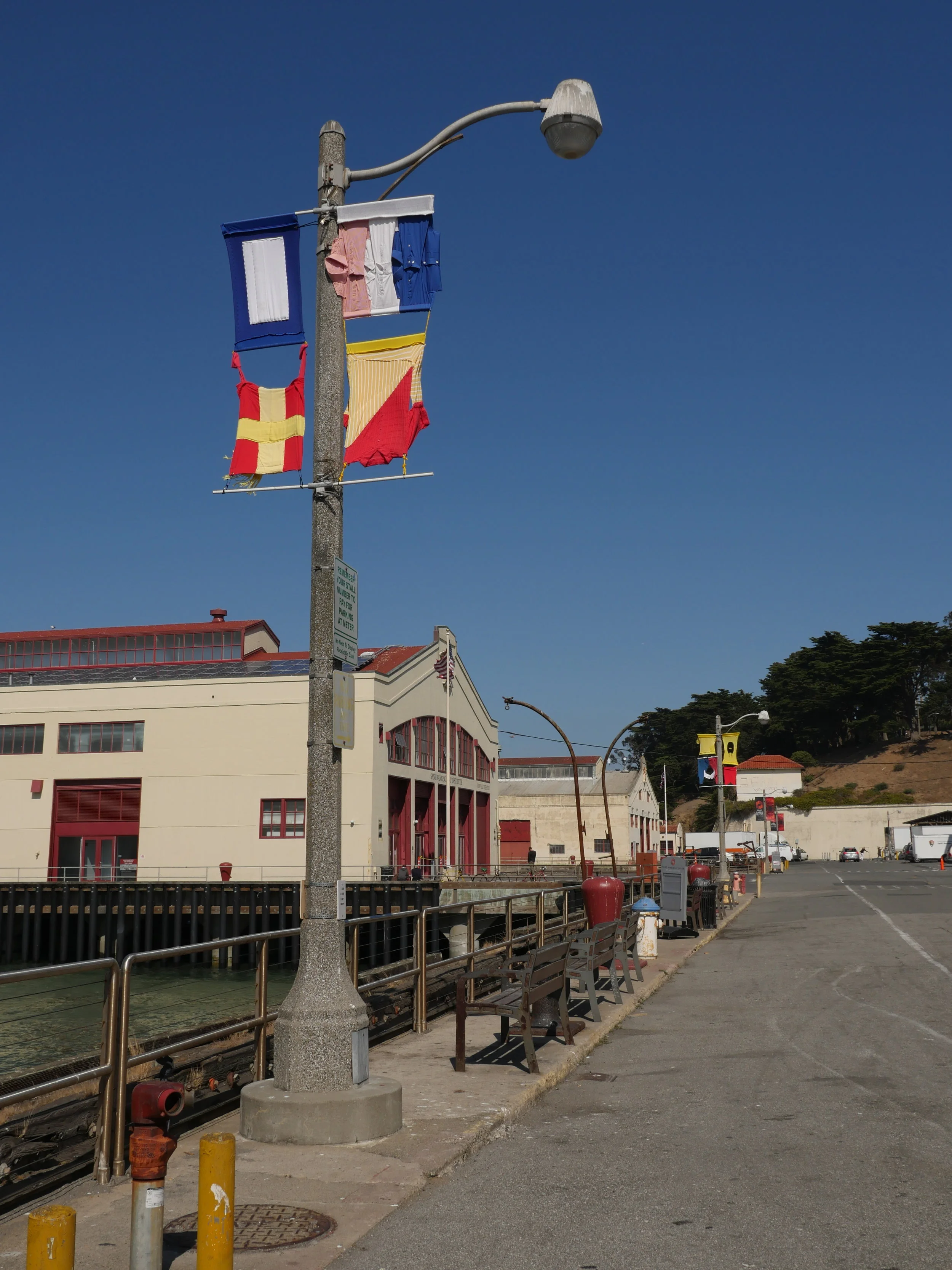 Hand-sewn signal flags installed on lampposts overlooking the bay