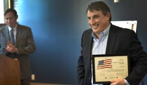 Cascade Management, Inc Portfolio Manager Joe Vennes accepts an award on behalf of his company for providing units to homeless Veterans. Portland City Commissioner Dan Saltzman looks on. 