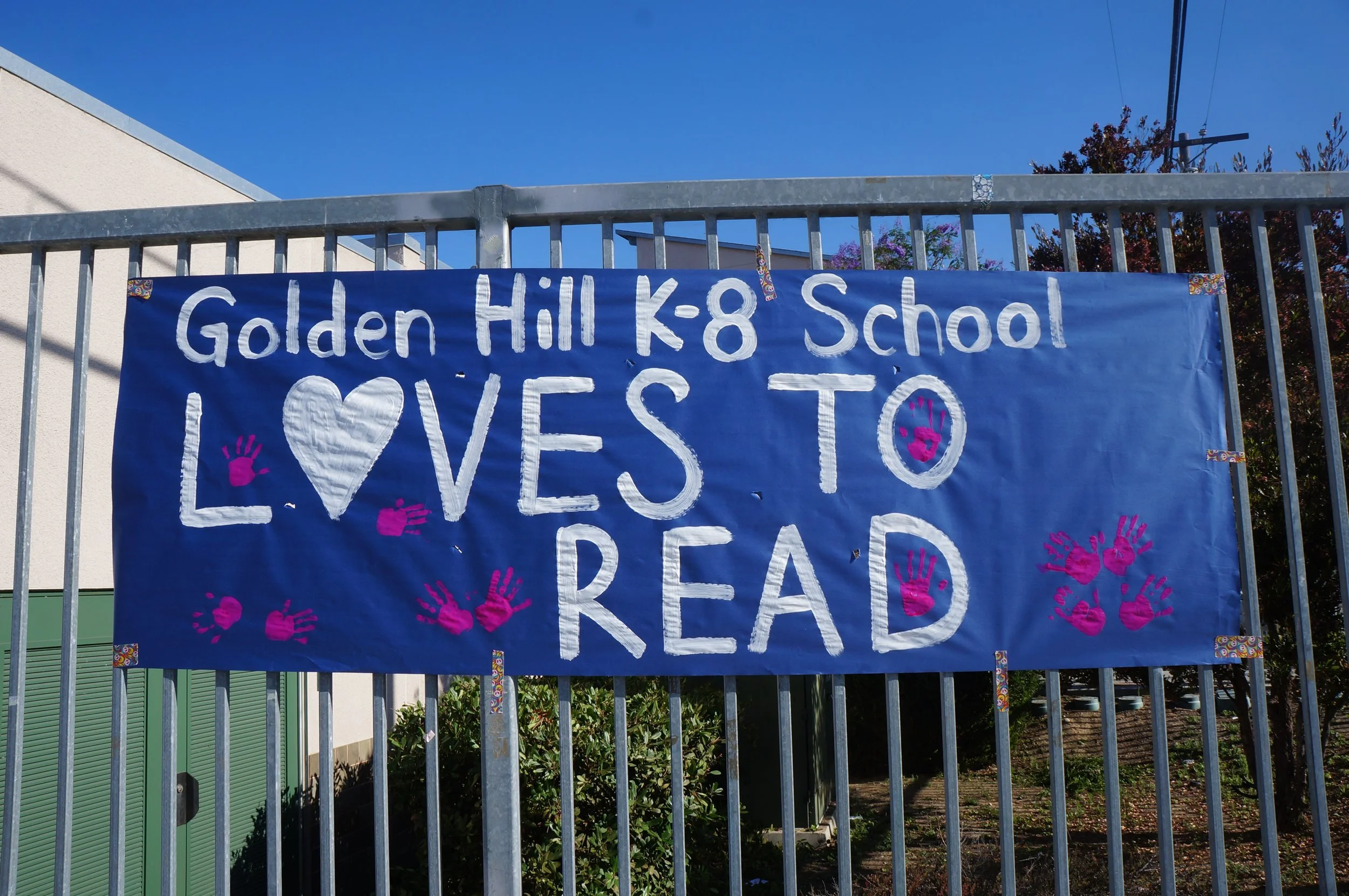 The students at Golden Hill made a sign for the giveaway event. It says "Golden Hill K-8 School Loves to Read!"