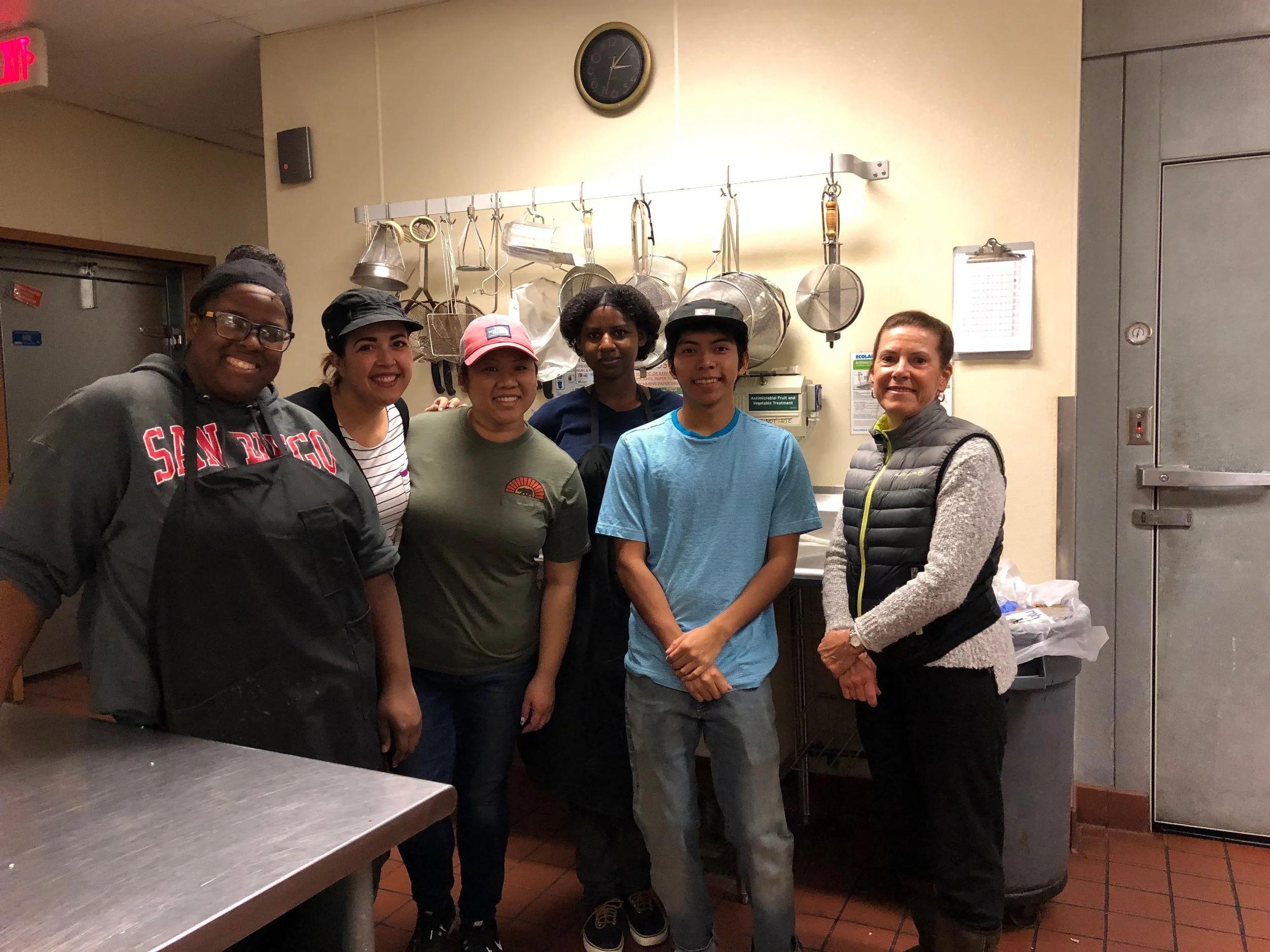 An image of our scholarship students and mentors at a volunteer day at Kitchens for Good.
