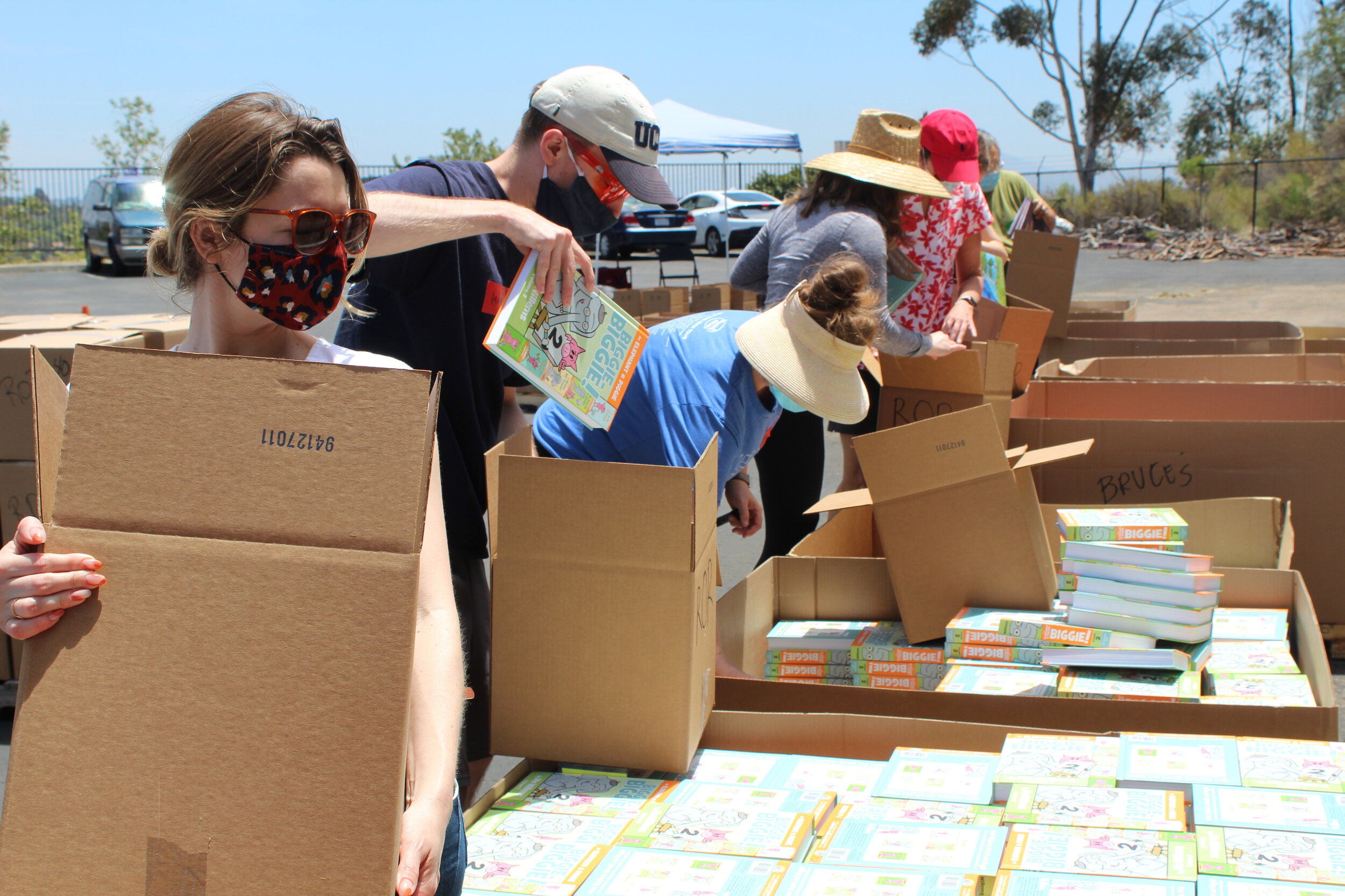 Volunteers wearing masks help box and sort hundreds of books.