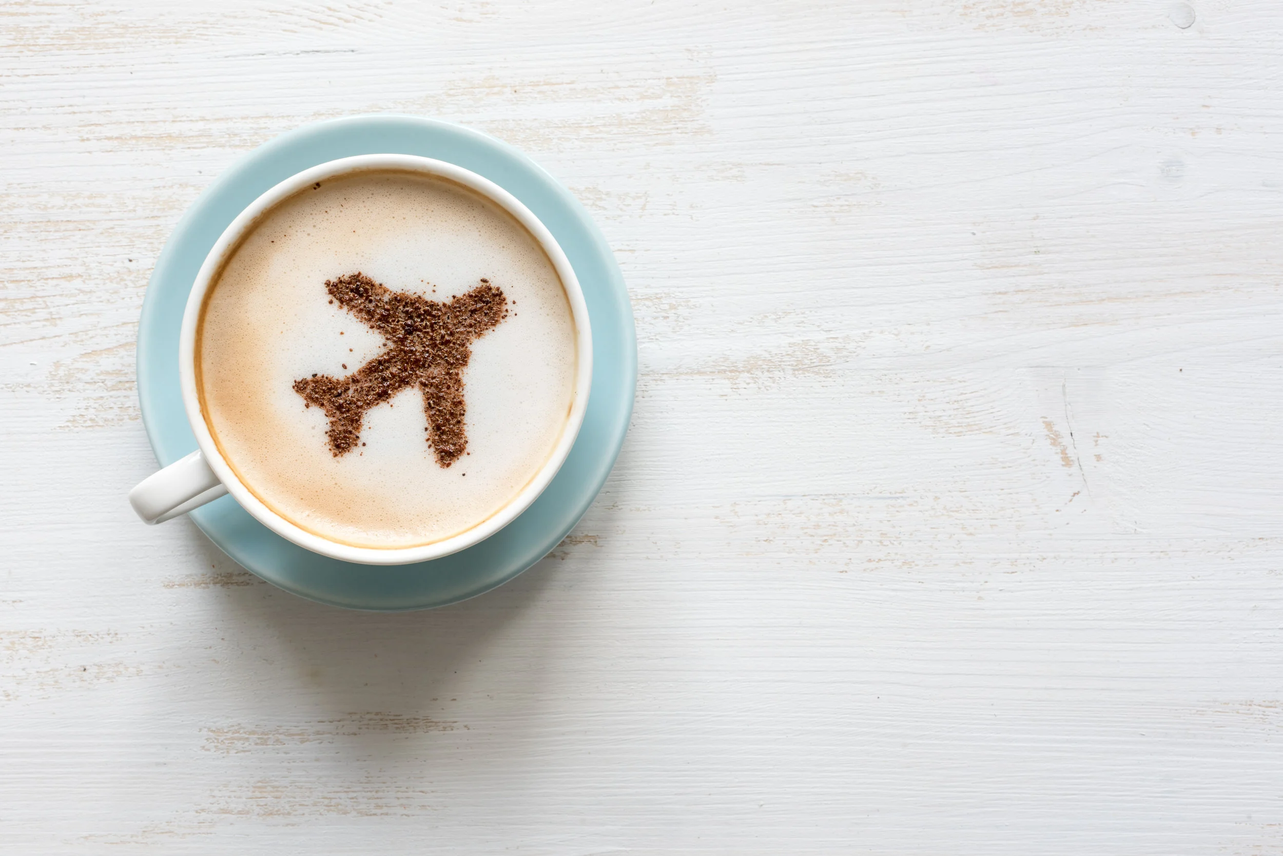 Airplane made of cinnamon in coffee. Cup of Cuppuccino. Travel concept