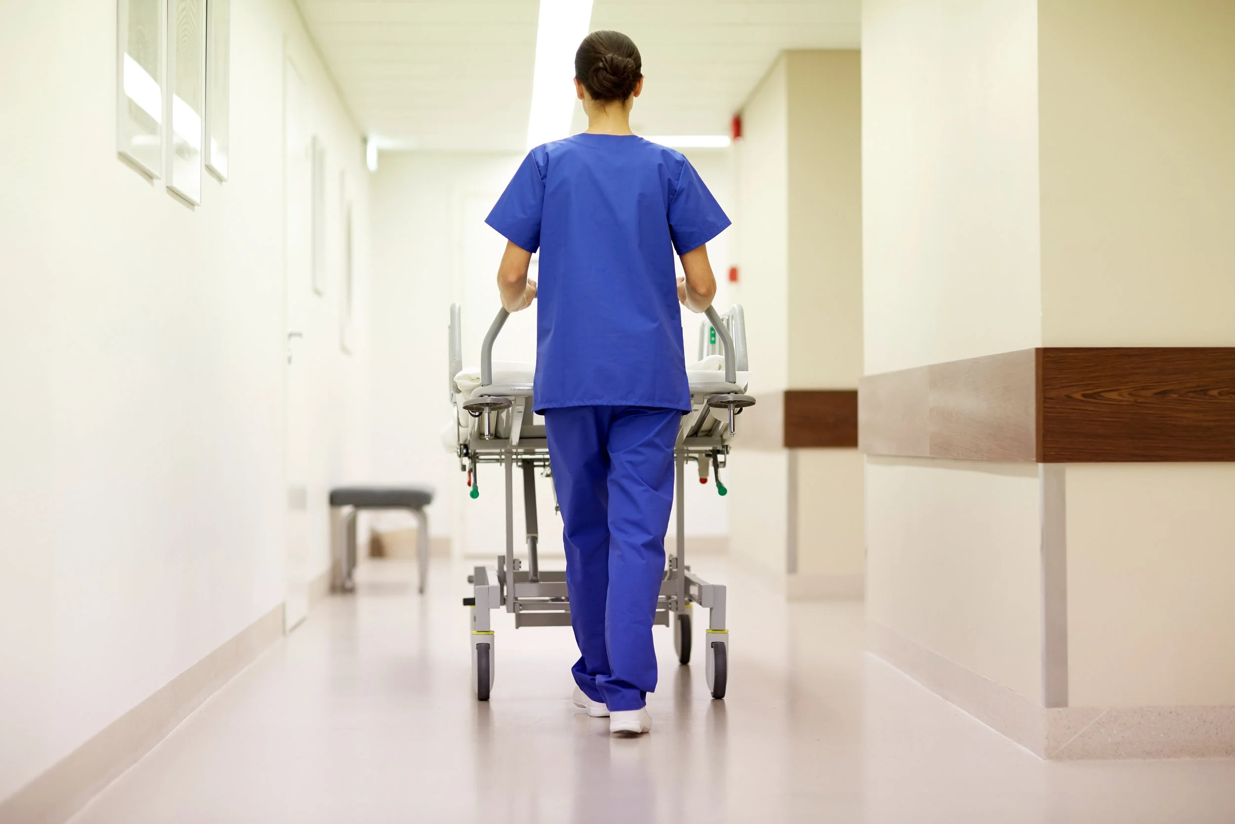 nurse carrying hospital gurney to emergency room