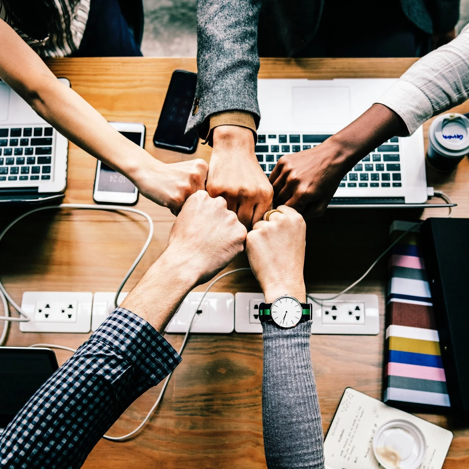 Don't expect the imidiate fist-bump over the laptop laden conference table like you see in this photograph. When commissioning a custom LMS you have to balance the diverse perspectives among the diverse stakeholders involved with commissioning a custom LMS. It will take a lot of hard work and horse trading to get everyone on the same bandwagon. Photo courtsey of rawpixel on Unsplash