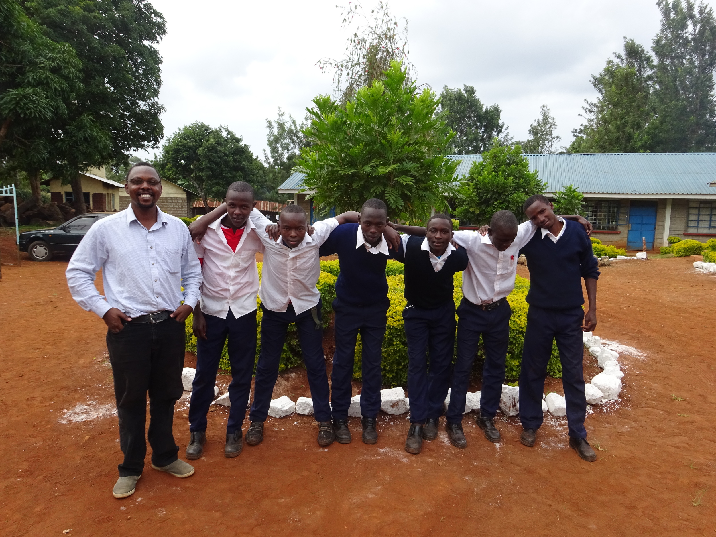Chairman of Moving Mountains Kenya, Gilbert Njeru with six students from the polytechnic college in Embu
