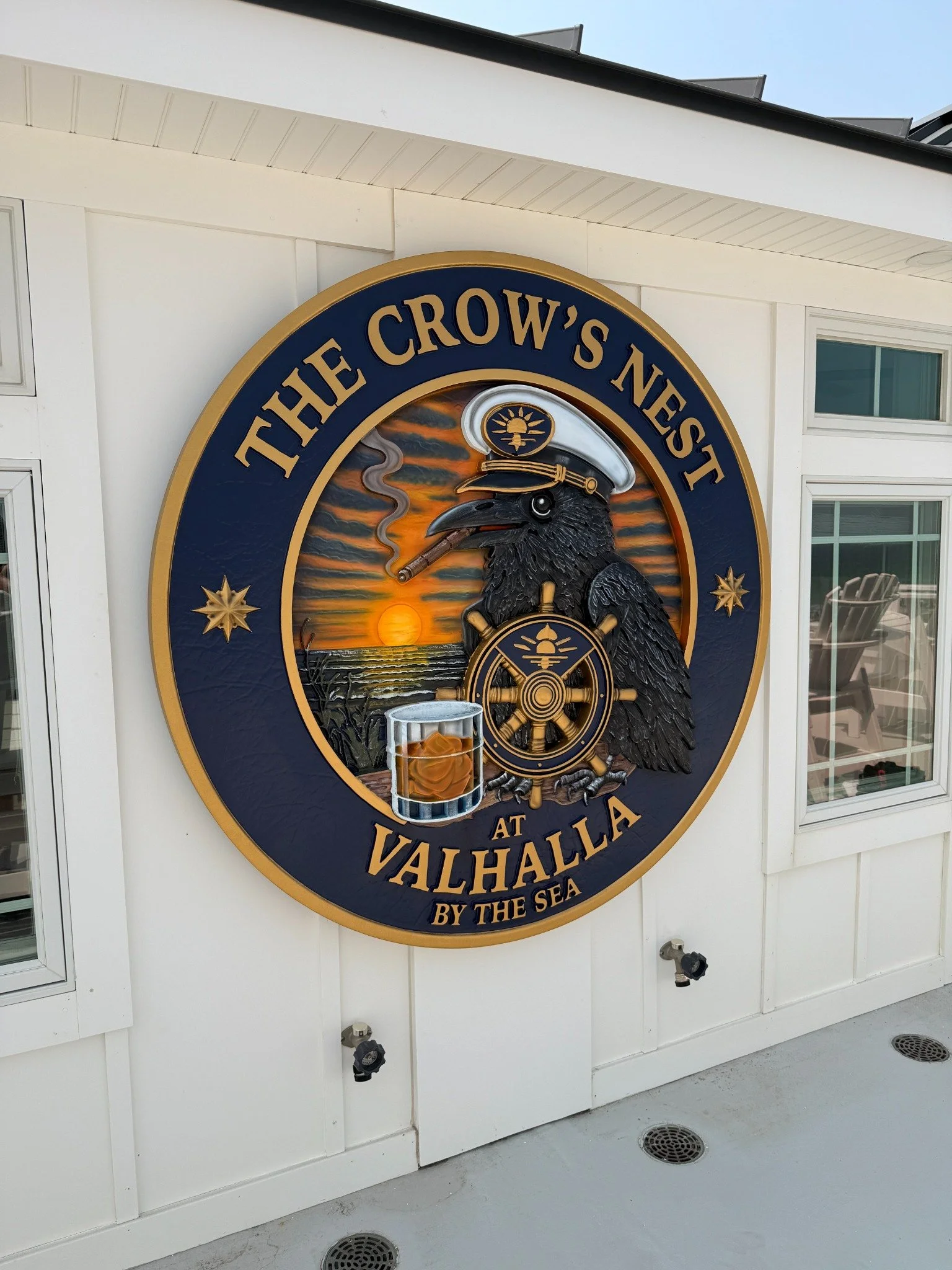 Hand-painted carved HDU Crow's Nest at Valhalla vacation home sign with nautical crow, ship's wheel and ocean sunset
