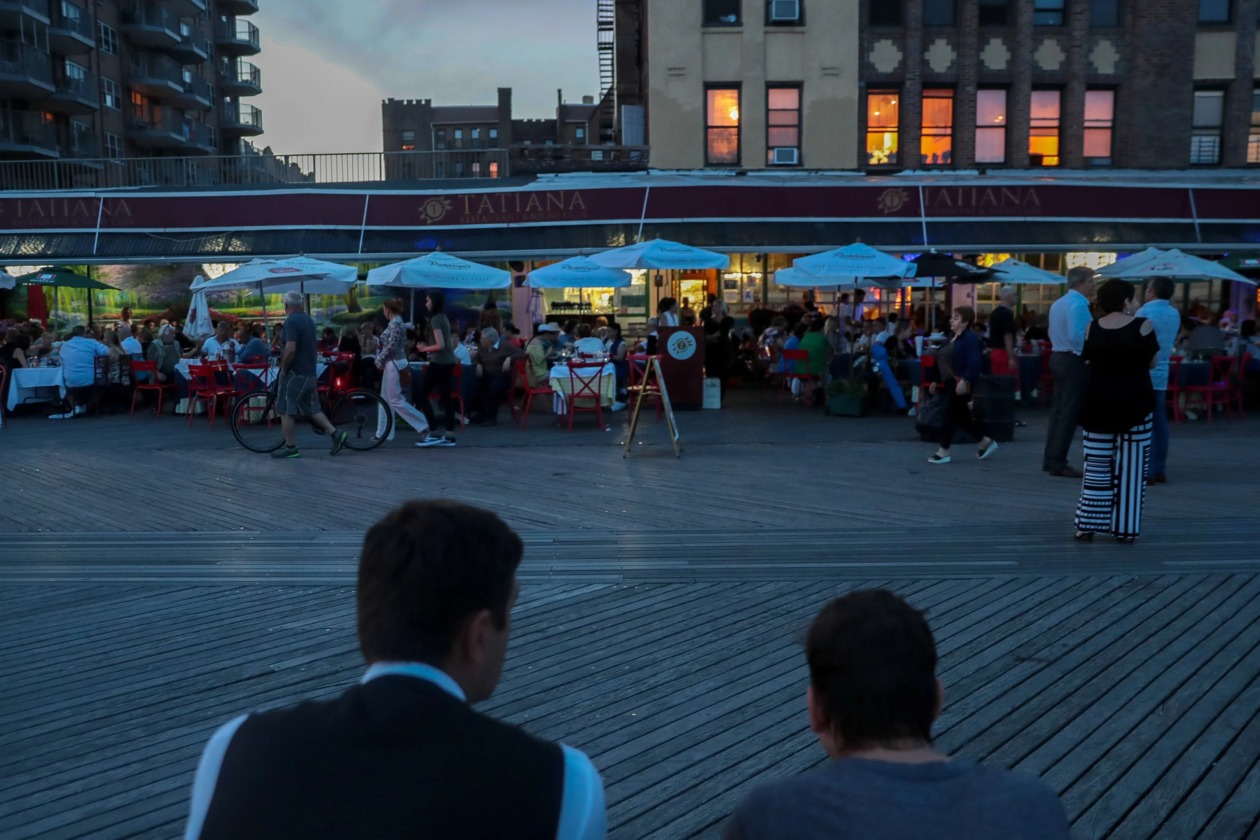 A waiter sits on the boardwalk during a cigarette break in Brighton Beach.