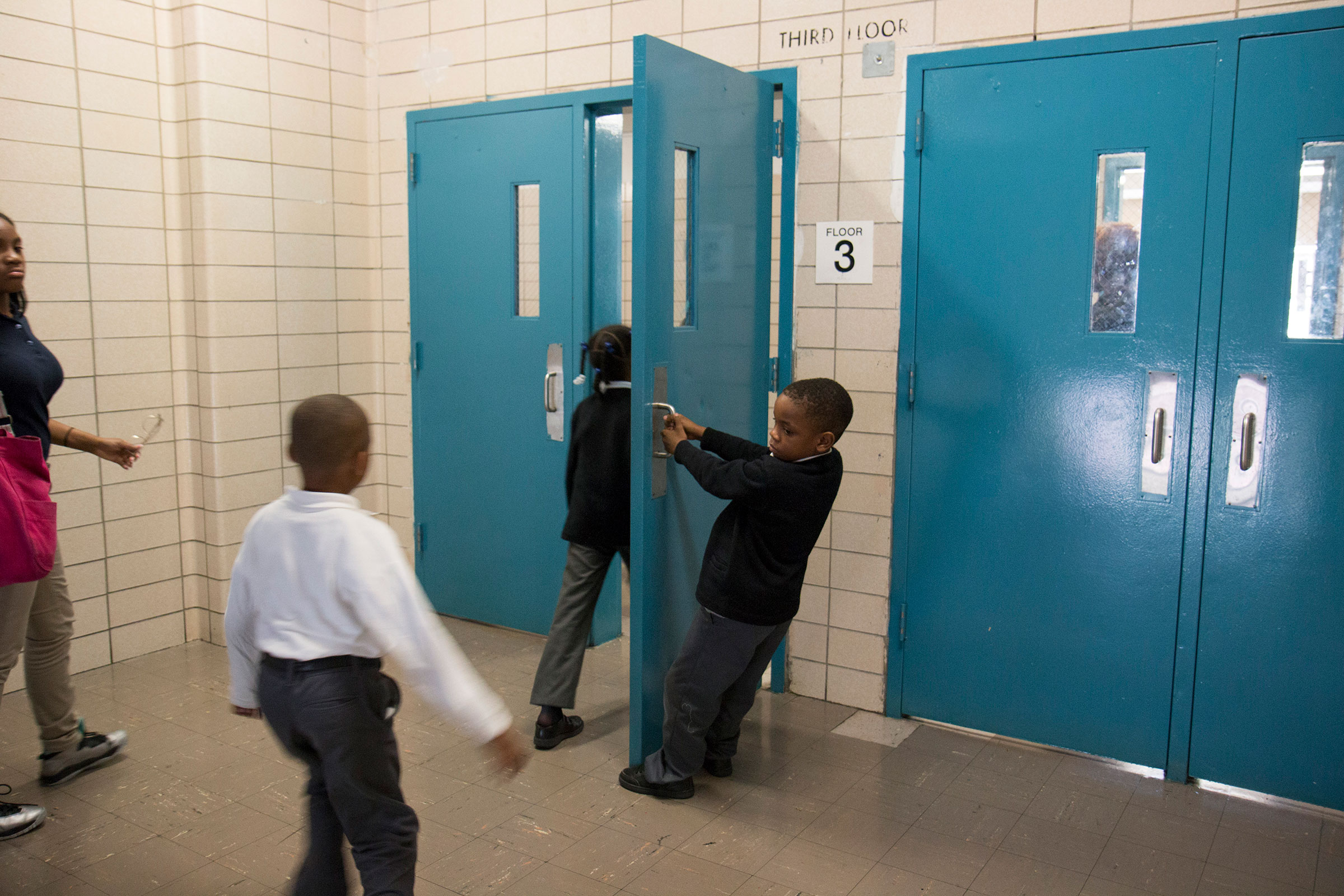  Second grader, Aiden, opens the door to the hall for fellow students and teachers at Leadership Prep Canarsie in Brooklyn, NY. 