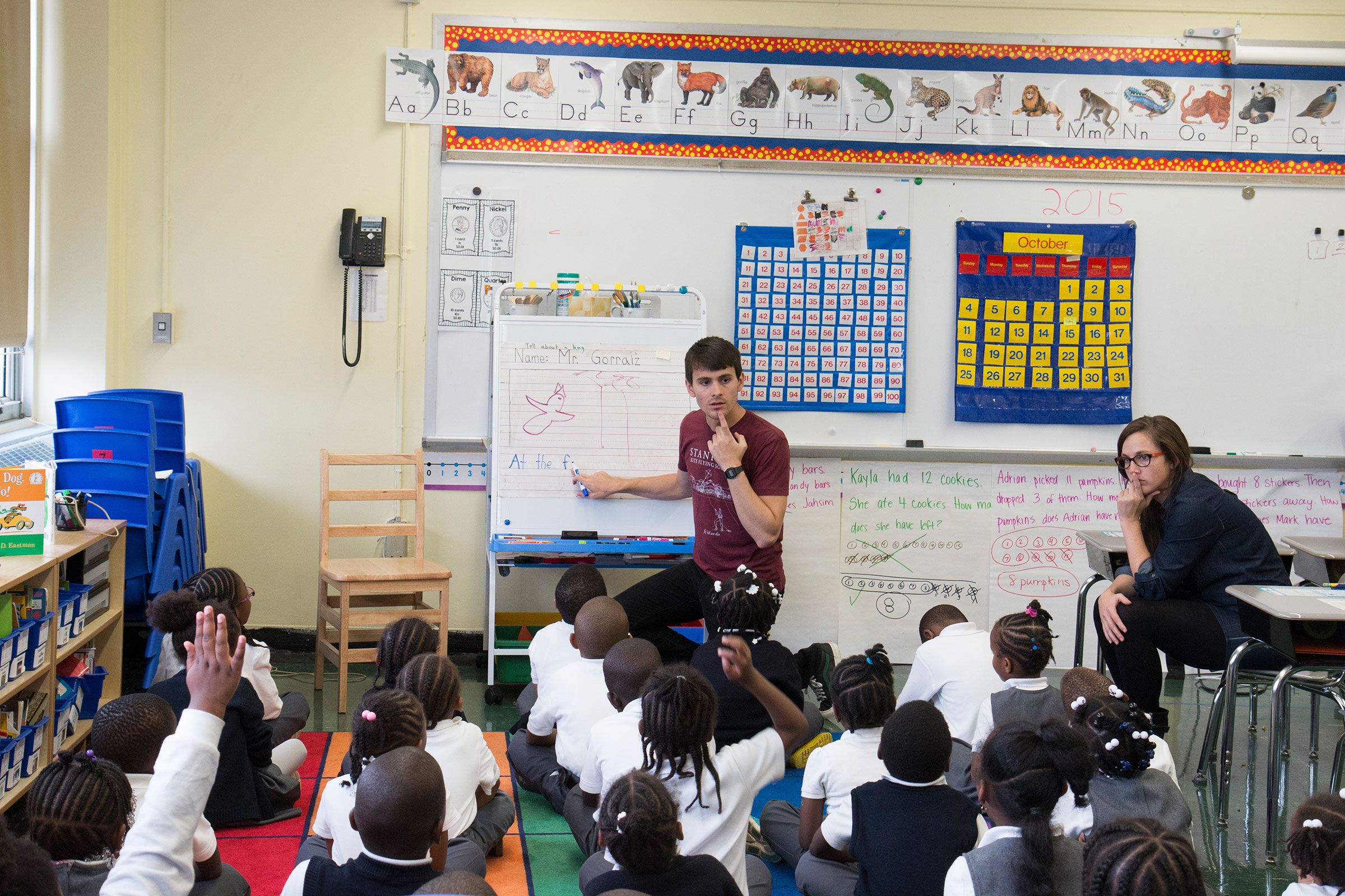  Principal Emily Hoefling (right) observes kindergarten teacher, Greg Gorraiz (left) while he teaches a lesson on sounding out words. 