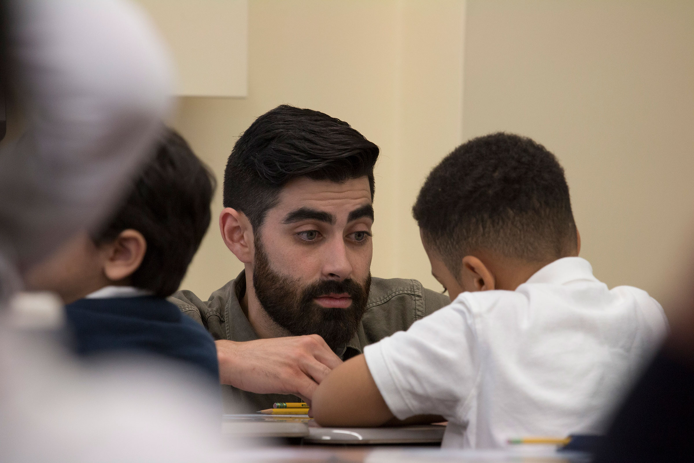  Second grade teacher, Kevin Grijalva, talks to a student who has difficulty staying motivated during class. 