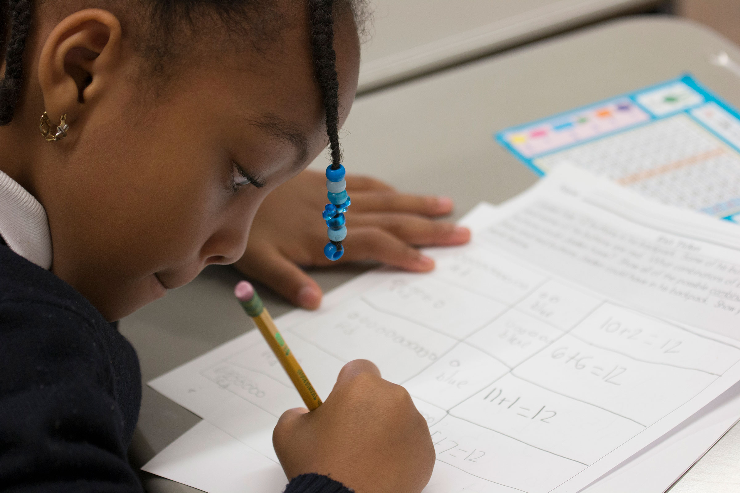  First grader, Heaven, fills out a math worksheet. 