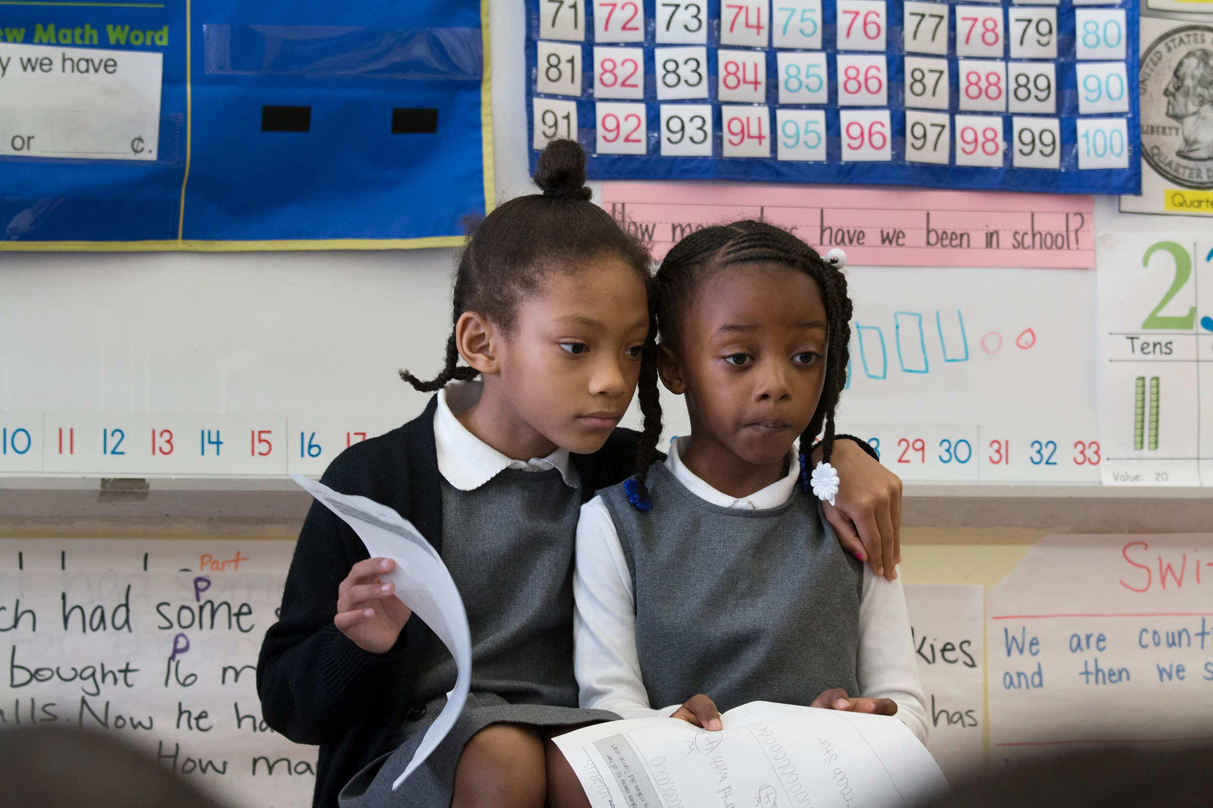Students Kai (left) and Madison (right) sit in front of the class to discuss a math lesson.
