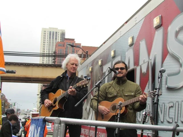 Bucky Halker and Yahvi Pichardo lead the crowd in singing at the 2014 May Day Celebration at the Haymarket Memorial.